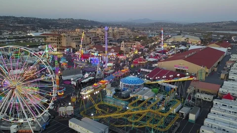 Drone slowly fly over fair carnival rides and midway amusements in late day 库存影片 98268371