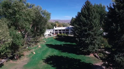 Drone slowly moves through trees at main entrance 스톡 동영상 102671521