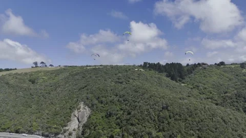Drone slowly pans right with group of four paragliders on a sunny day Stock Footage 326765051