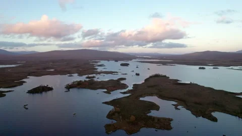 A drone slowly rises above  a patchwork landscape of islands amongst fresh Stock-Footage 227122039