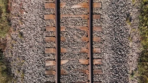 Drone slowly rising from a low elevation to height looking down railway line. Stock Footage 116753066