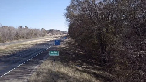Drone Smith County Sign and Freeway Traffic Creek Reverse Stock Footage 99603644