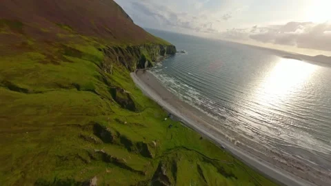 Drone soaring above a beautiful bay and cliffs towards a paraglider. Stock Footage 274179455