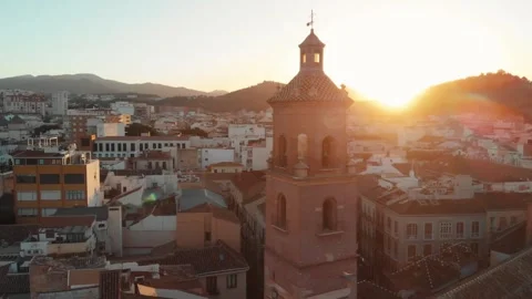 Drone soaring over malaga city at golden hour, illuminating historic church.. Stock Footage 341685313