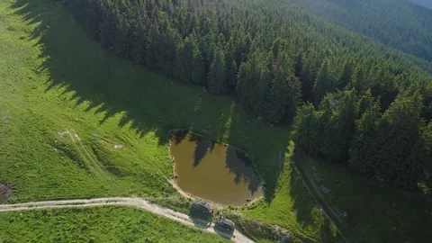 Drone Soaring Over Mountain Lake Encircled by Lush Greenery in Summer Video stock 255520045