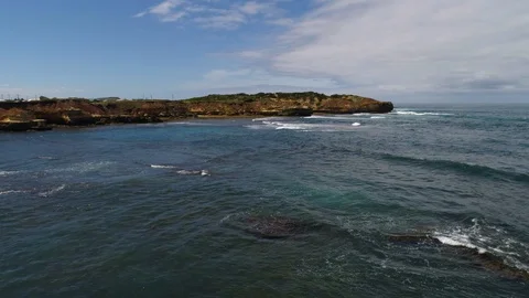 Drone soaring up over the rocky coastline to reveal Peterborough, Australia. Stock Footage 87858846