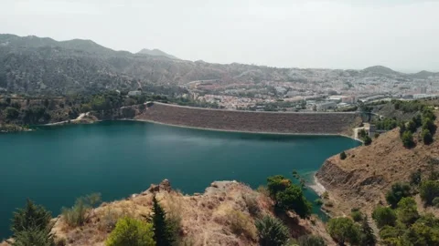 Drone soaring over vast turquoise reservoir behind imposing concrete dam, o.. Stock Footage 341828642