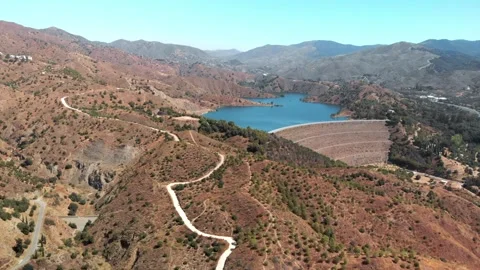 Drone soaring over winding mountain road, revealing vast reservoir and conc.. Stock Footage 341828665