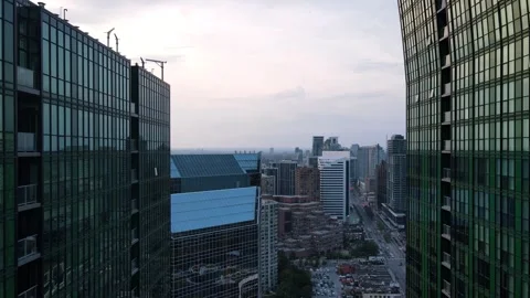 Drone Soars Between Towers, Showcasing Cityscape and Flowing Traffic Below Stock Footage 289697558