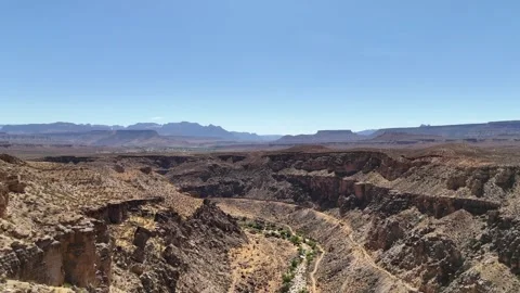 Drone soars over couple at canyon edge revealing vast Utah landscape Vídeo Stock 340580621