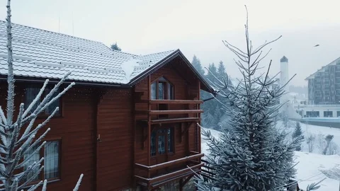 A drone spans between two Christmas trees to a wooden house, aerial shot 스톡 동영상 128150227