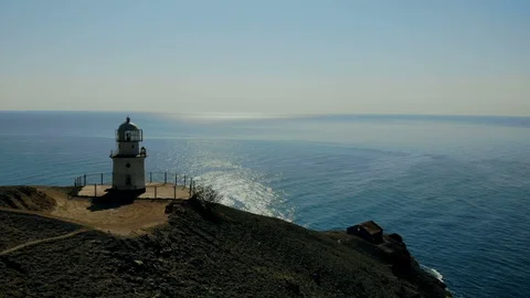 Drone spin shot of lighthouse on background of sea. Beautiful white lighthouse Stock Footage 123221375