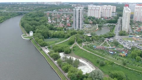 Drone spiraling down over riverside residential district Vídeos de archivo 332684125