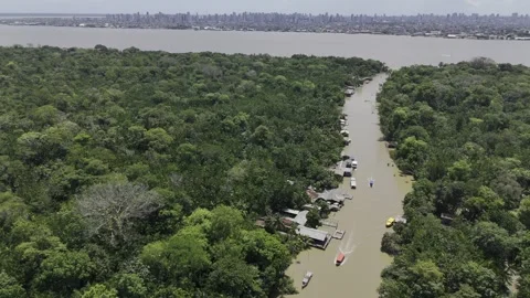 Drone spirals down around small brown river with red boat Stock-Footage 284465808
