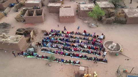 Drone spirals over a poor village in Nigeria as food is distributed to locals Vídeo Stock 313661562