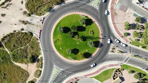 The drone stands still over a roundabout through which cars drive. Stock Footage 132591851
