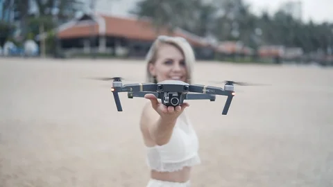 Drone is starting to taking off from woman's hands at seashore near the ocean 動画素材 93931049