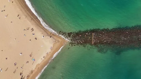 Drone static shot of glass-shaped beach with turquoise waves, Barcelona, Spain. Stock Footage 319944321
