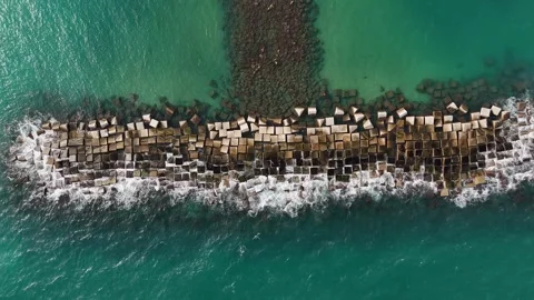 Drone static shot of waves crashing against rocks, turquoise water, Barcelona. Stock Footage 319944333