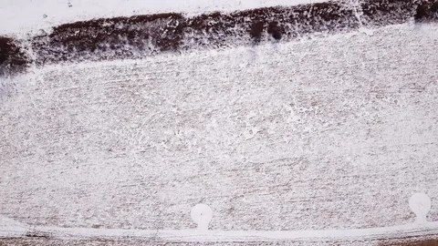 Drone straight down melting snow covered field Video stock 104307810