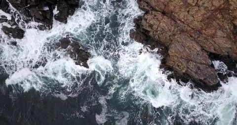 Drone straight down moving up from shore cliff waves splashing 動画素材 124509360
