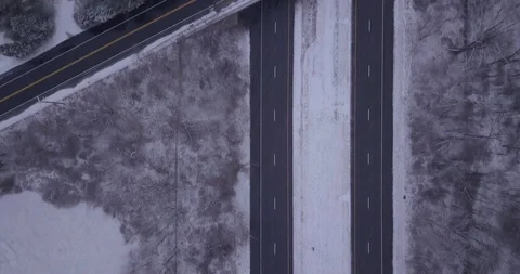 Drone straight down on snow fall highway in snow storm overpass Stock Footage 101127310