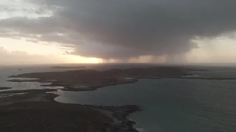 Drone Sunset behind rain from a single cloud over Scottish islands 4K Stock Footage 299327064