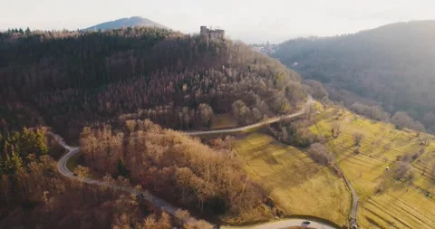 Drone sunset castle road in forrest trees germany golden cars Stock Footage 170442757