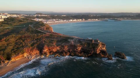 Drone sunset over Nazaré Lighthouse and Atlantic waves in Portugal. Stock Footage 329118720