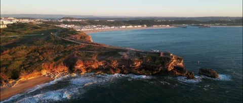 Drone sunset over Nazaré Lighthouse and Atlantic waves in Portugal. Stock Footage 329118833