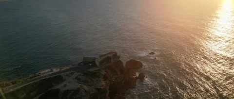 Drone sunset over Nazaré Lighthouse and Atlantic waves in Portugal. Stock Footage 329118844