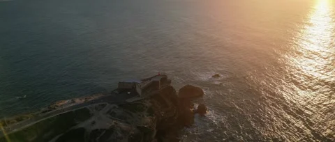 Drone sunset over Nazaré Lighthouse and Atlantic waves in Portugal. Stock Footage 329118854