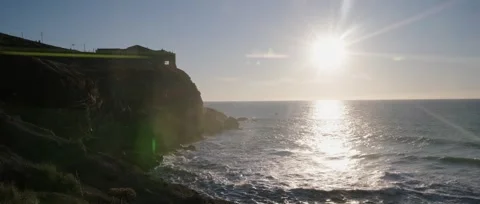 Drone sunset over Nazaré Lighthouse and massive Atlantic waves in Portugal. Stock Footage 329118961