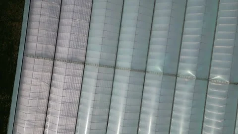 Drone - Swirling Shot Looking Down &amp; Rising from Greenhouses Stock Footage 314227634