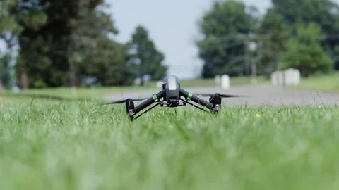 Drone takeoff from grass exit top frame.  Wide shot. Stock Footage 80133481