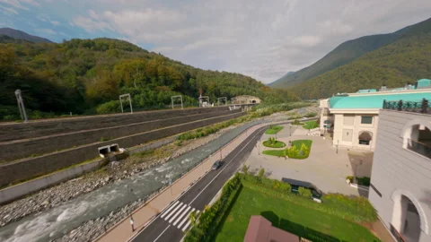 Drone takeoff from hotel lawn toward forested hills Stock Footage 311078841