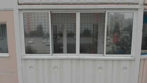 A drone takes a close-up of a window of an apartment building moving Stock Footage 118888216