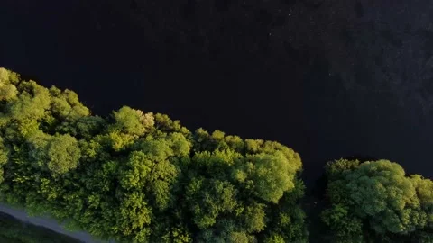 The drone takes off over the river and the forest through which the road goes Stock-Footage 155884790