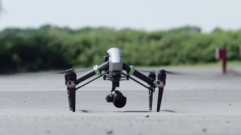 Drone takes off from pavement.  Exits shot top right. Stock Footage 80133487