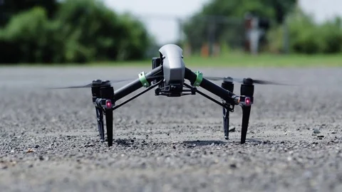 Drone takes off from pavement, hovers-exits top right Stock Footage 80133489
