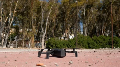 Drone taking off from the ground outdoor. Trees in the background. Stock Footage 118765024