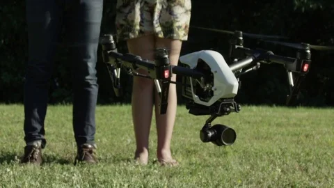 Drone taking off with two young attractive pilots in the background. Slow Motion Stock Footage 82594548
