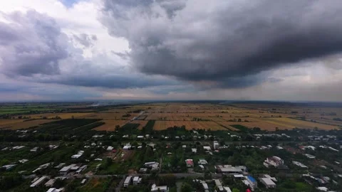 Drone tilt-down of dramatic rain clouds over Mekong Delta countryside Video stock 337756928