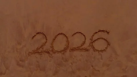 Drone Tilt Down Shot Revealing 2026 Written in Beach Sand Stock Footage 323745323