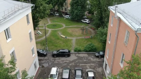 Drone tilts up above inner yard between buildings in Podolsk Vidéo 327685023