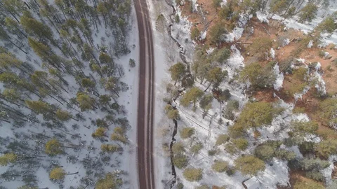 Drone tilts up along windy mountain road in the winter Stock Footage 101980425