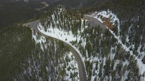 Drone tilts up from road on a mountain to vast mountainous landscape Stock-Footage 167676351