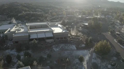 Drone tilts up from small snowy New Mexican town to mountains Stock Footage 167669963