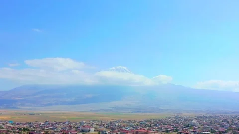 Drone tilts upward above an eastern Turkish city toward Mount Ararat, revealing Vídeo Stock 344835652