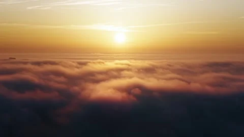 Drone time-lapse flying above moving clouds with bright orange sun on horizon Stock Footage 318147310